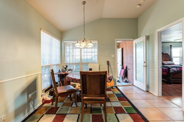 dining room featuring lofted ceiling, tile patterned floors, and a notable chandelier