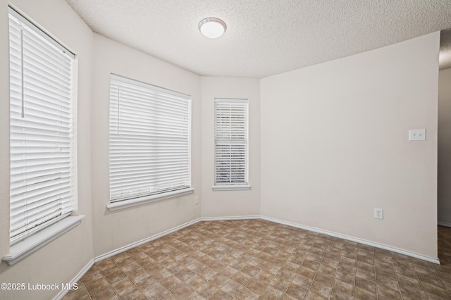 1712 75th St, Lubbock, TX 79423 - unfurnished room featuring a textured ceiling, healthy amount of natural light, and baseboards