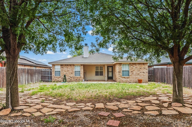 1712 75th St, Lubbock, TX 79423 - rear view of property with a chimney, brick siding, a fenced backyard, and a patio area
