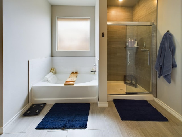 bathroom featuring shower with separate bathtub