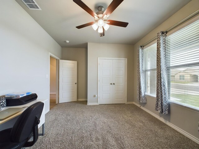 carpeted office space featuring ceiling fan