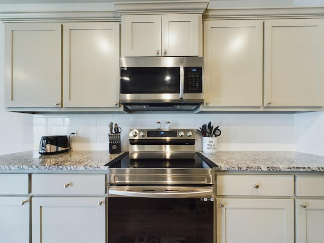 kitchen featuring tasteful backsplash, stainless steel appliances, and light stone countertops