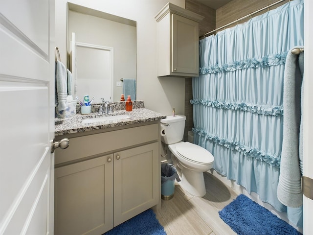 bathroom with a shower with curtain, vanity, hardwood / wood-style floors, and toilet