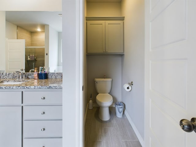 bathroom with vanity, a shower with door, and toilet