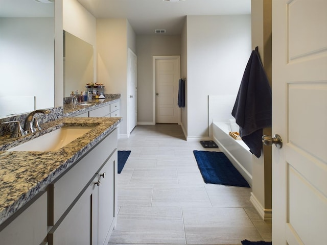 bathroom with vanity and a tub to relax in