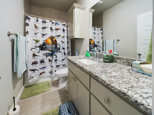 bathroom featuring vanity, walk in shower, and toilet