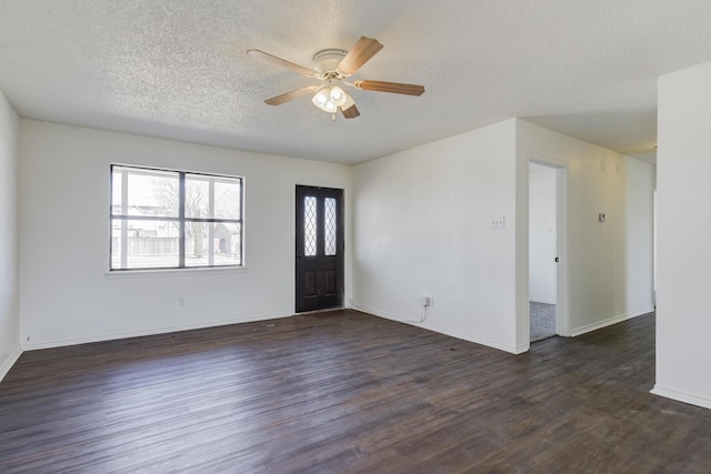 foyer entrance with ceiling fan, a textured ceiling, baseboards, and dark wood-style flooring