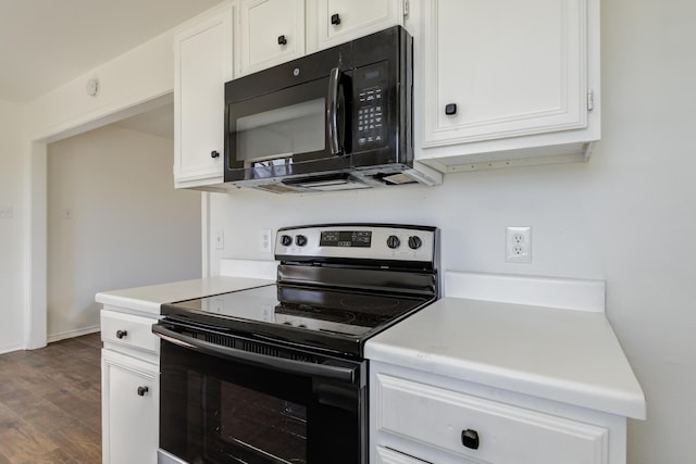 kitchen with black microwave, light countertops, electric range oven, and white cabinets