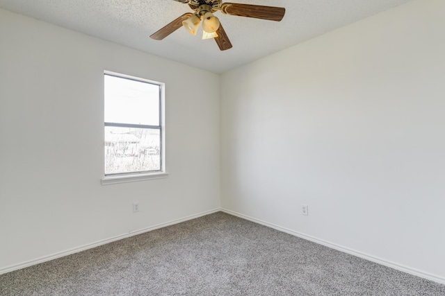 carpeted spare room featuring ceiling fan, baseboards, and a textured ceiling