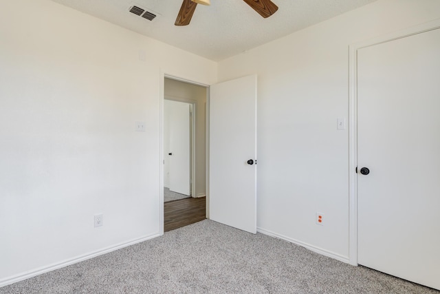 unfurnished bedroom with light carpet, baseboards, visible vents, and ceiling fan