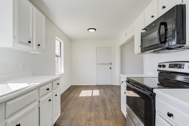 kitchen featuring stainless steel range with electric stovetop, white cabinetry, black microwave, and light countertops