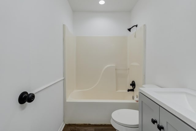 bathroom with shower / bathtub combination, vanity, wood finished floors, and toilet