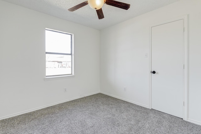 carpeted spare room featuring a ceiling fan, a textured ceiling, and baseboards