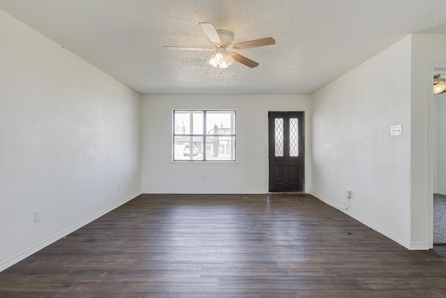 foyer entrance featuring a textured ceiling, ceiling fan, dark wood-type flooring, and baseboards