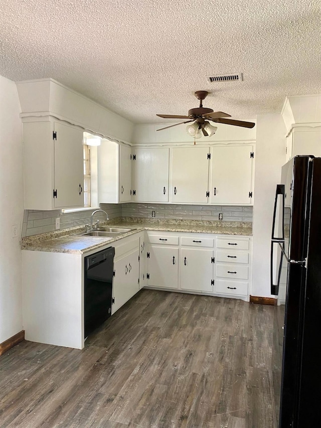 kitchen with dark hardwood / wood-style floors, sink, white cabinets, decorative backsplash, and black appliances