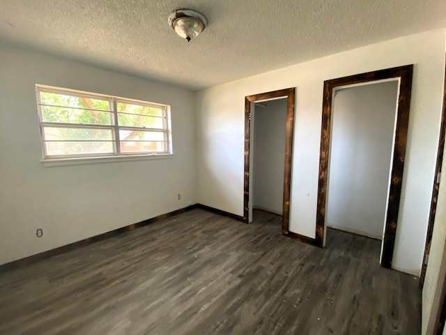 unfurnished bedroom with dark hardwood / wood-style floors and a textured ceiling