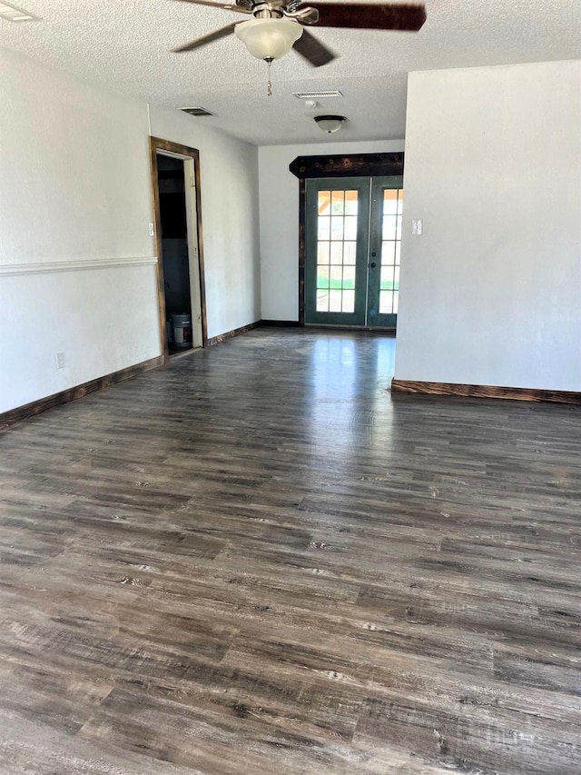 unfurnished room featuring dark hardwood / wood-style flooring, ceiling fan, french doors, and a textured ceiling