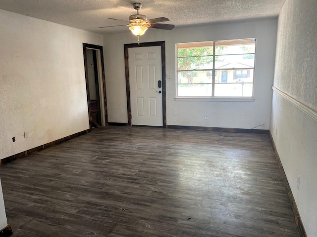 interior space with ceiling fan, dark hardwood / wood-style floors, and a textured ceiling