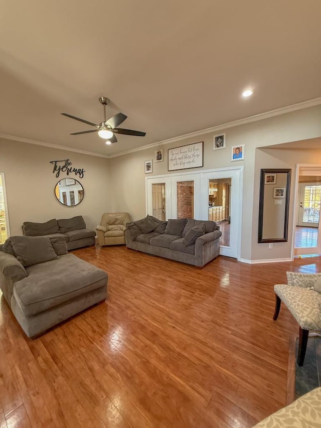 living room featuring crown molding, hardwood / wood-style flooring, and ceiling fan