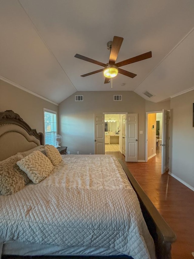 bedroom featuring lofted ceiling, hardwood / wood-style flooring, crown molding, and ceiling fan