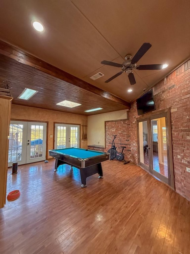 game room featuring hardwood / wood-style flooring, brick wall, pool table, and french doors