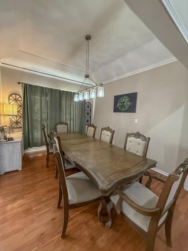 dining space featuring hardwood / wood-style floors and crown molding