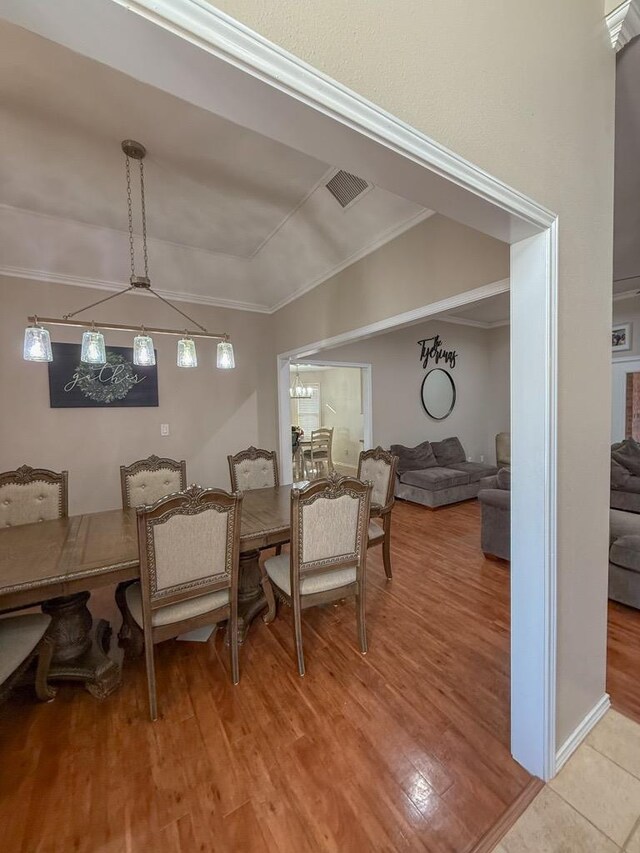 dining room with hardwood / wood-style flooring and ornamental molding