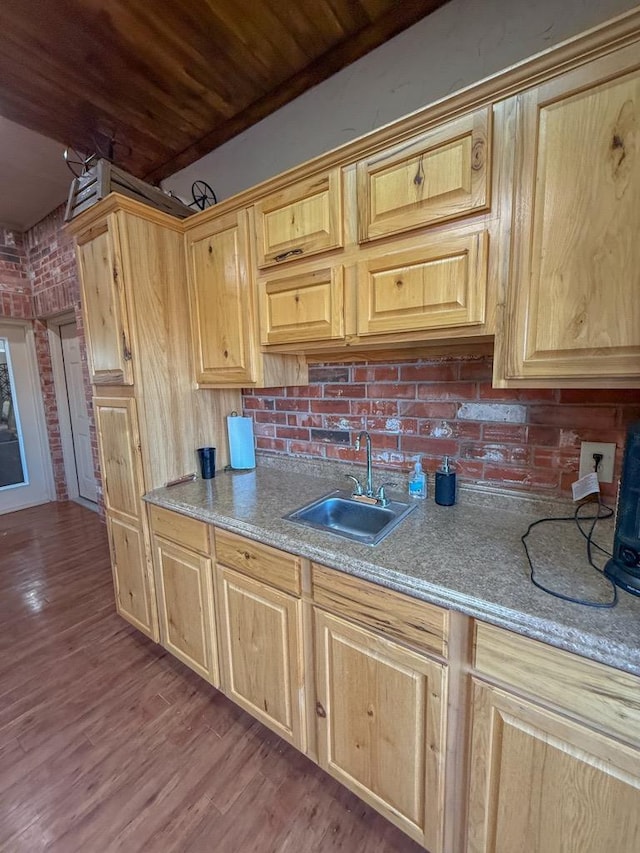 kitchen with brick wall, sink, hardwood / wood-style flooring, light brown cabinets, and wooden ceiling