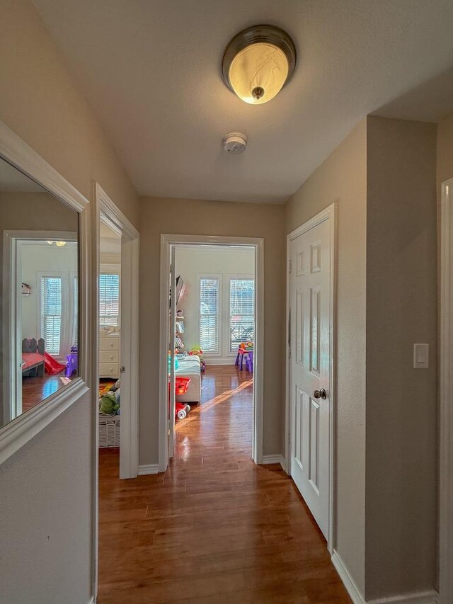 hallway with hardwood / wood-style flooring