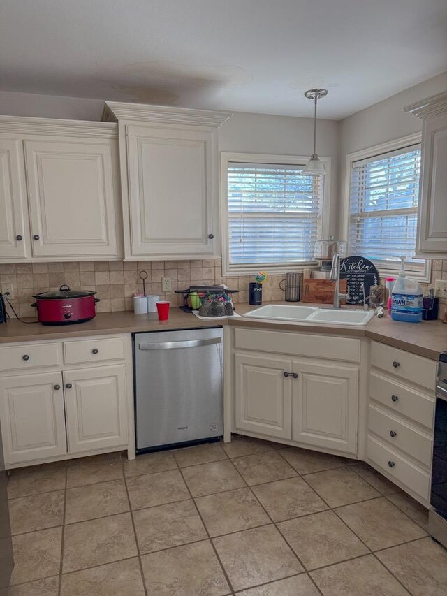 kitchen with stainless steel appliances, white cabinetry, sink, and backsplash