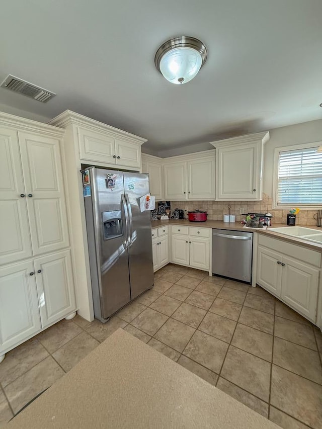 kitchen with tasteful backsplash, sink, stainless steel appliances, and light tile patterned flooring