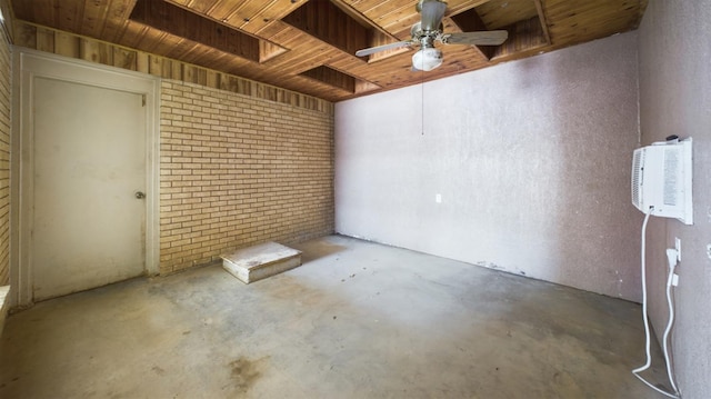 spare room featuring wooden ceiling, concrete floors, ceiling fan, and brick wall