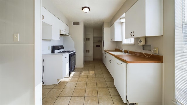 kitchen with sink, light tile patterned floors, white cabinetry, white dishwasher, and gas range