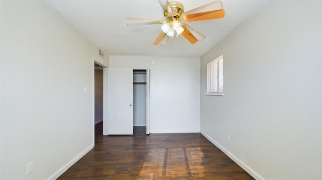 empty room with a textured ceiling, dark wood-type flooring, and ceiling fan