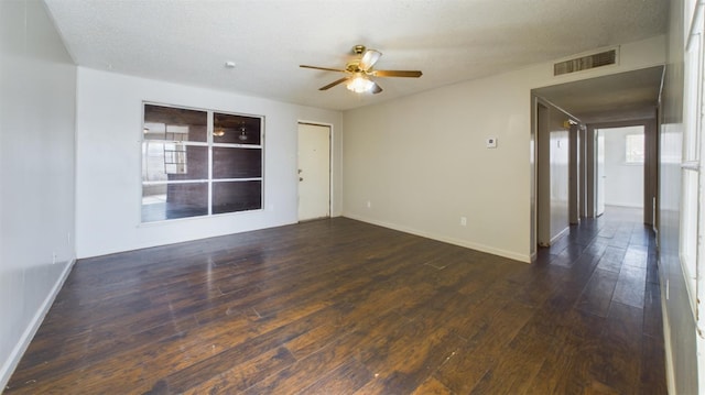 empty room with ceiling fan, a textured ceiling, and dark hardwood / wood-style flooring