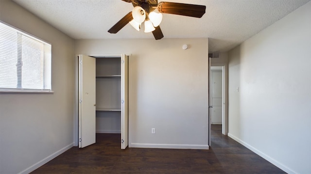 unfurnished bedroom featuring ceiling fan, dark hardwood / wood-style floors, a textured ceiling, and a closet