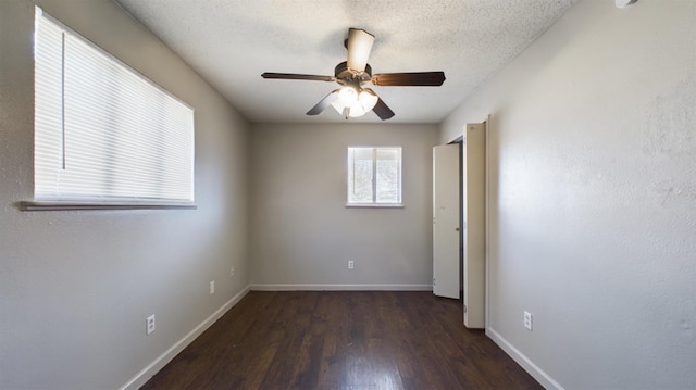 unfurnished room with ceiling fan, dark wood-type flooring, and a textured ceiling