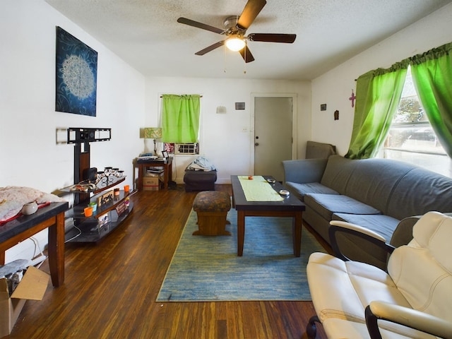 living room with a textured ceiling, a ceiling fan, and wood finished floors