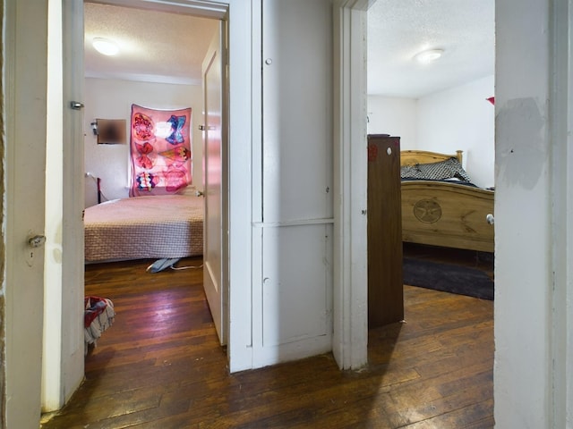 hallway with hardwood / wood-style flooring and a textured ceiling