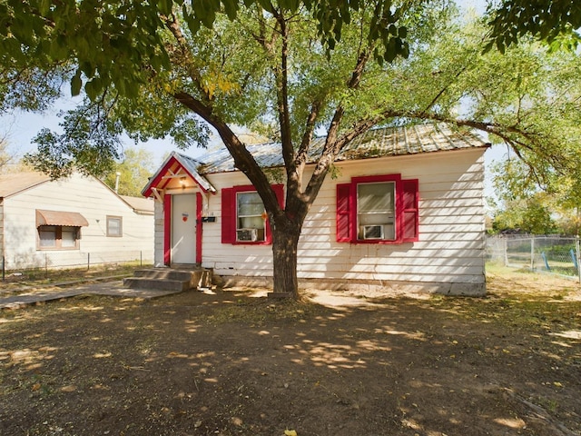 view of front of home with metal roof and fence