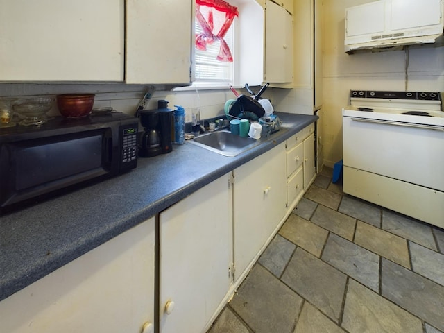 kitchen with a sink, white cabinetry, electric stove, dark countertops, and stone tile flooring