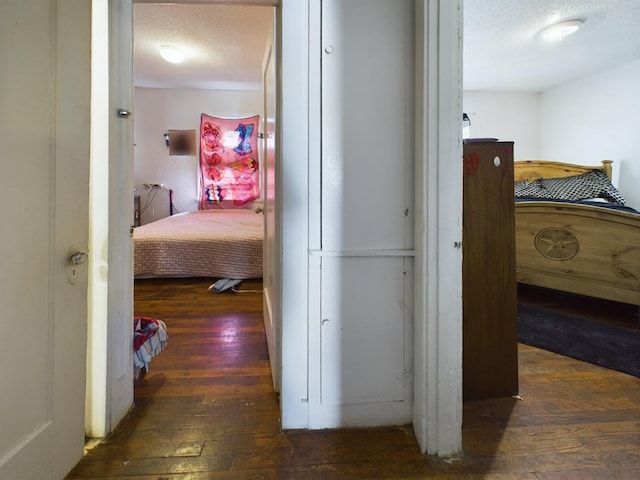 hallway featuring wood-type flooring and a textured ceiling