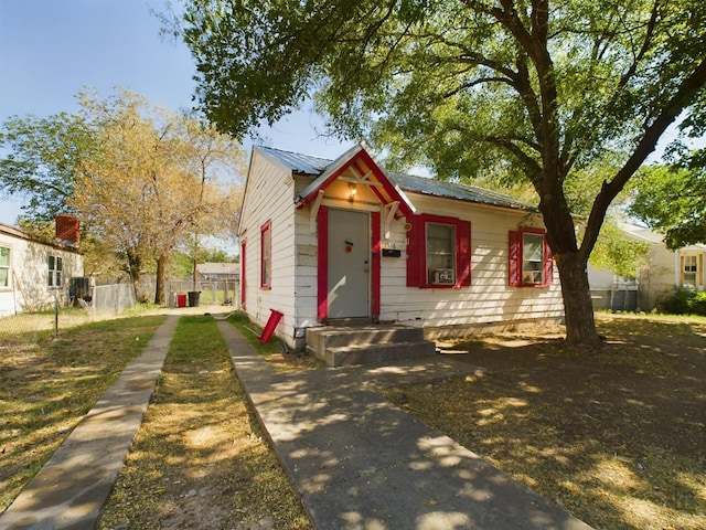 bungalow with metal roof and fence