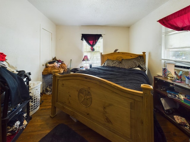 bedroom with a textured ceiling and wood finished floors