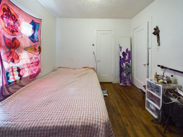 bedroom with a textured ceiling and wood finished floors