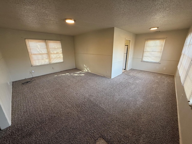 empty room with carpet flooring and a textured ceiling