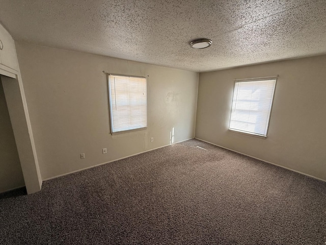 carpeted spare room featuring a textured ceiling