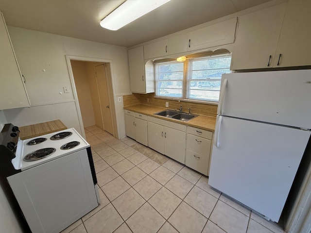 kitchen featuring sink, white appliances, white cabinets, and light tile patterned flooring