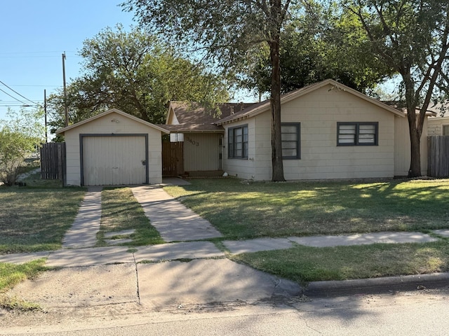 single story home with a garage, an outbuilding, and a front lawn