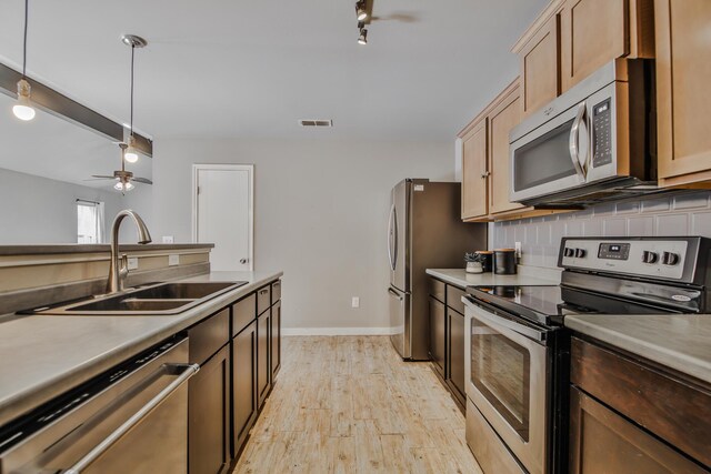 6205 21st St, Lubbock, TX 79407 - kitchen with stainless steel appliances, light wood finished floors, ceiling fan, tasteful backsplash, and pendant lighting